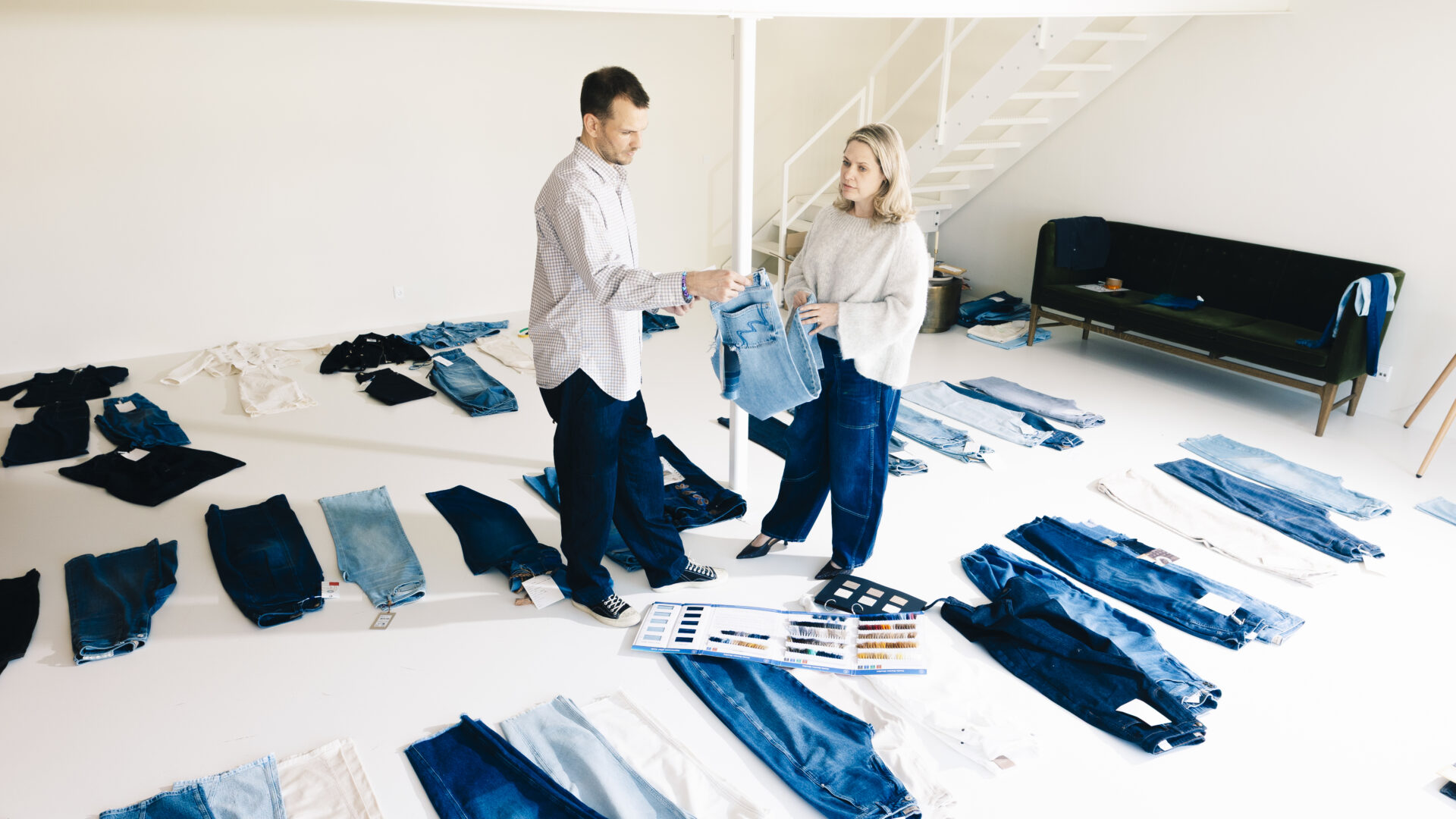 To personer står med i et showroom, hvor man kan se mange slags jeans