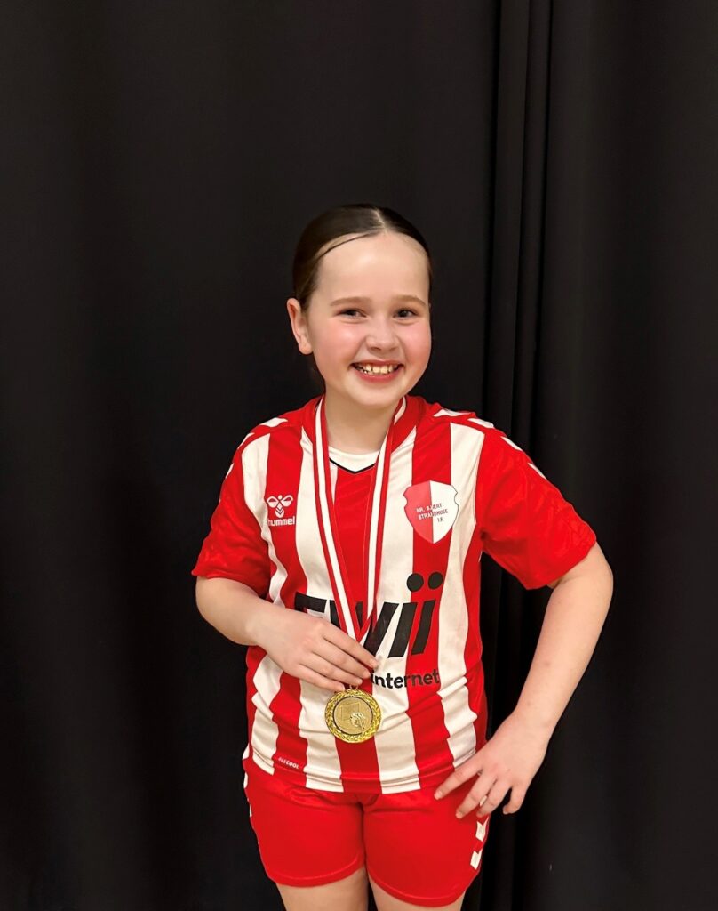 Egill og Stefanias datter i foldboldtøj med medalje om halsen