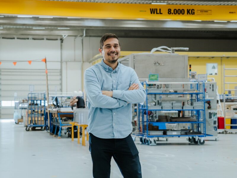 Evangelos står midt i en stor hal på sin arbejdsplads Grm Equipment