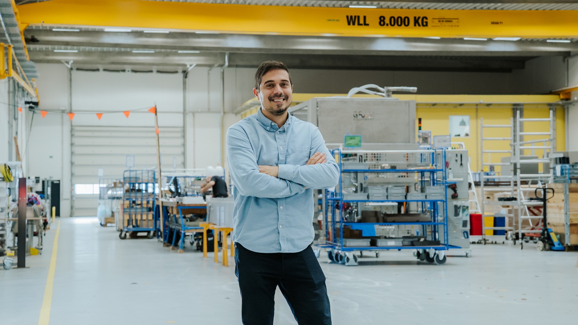 Evangelos står midt i en stor hal på sin arbejdsplads Grm Equipment