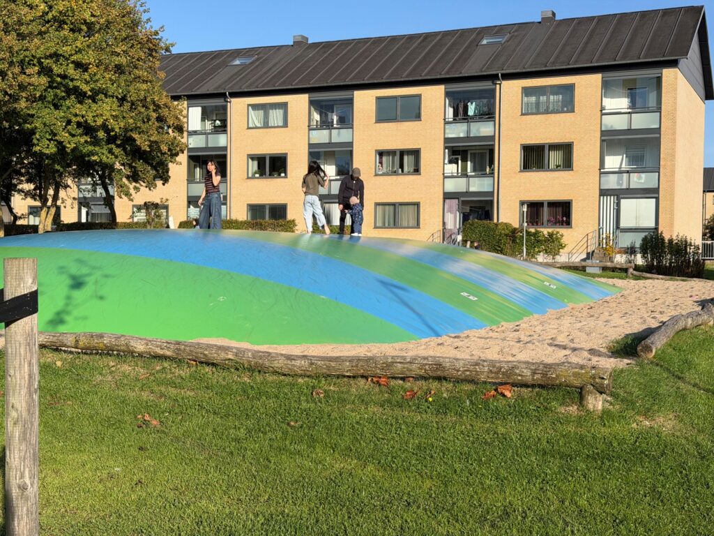 Børn på hoppepude foran boligblok i Munkevænget