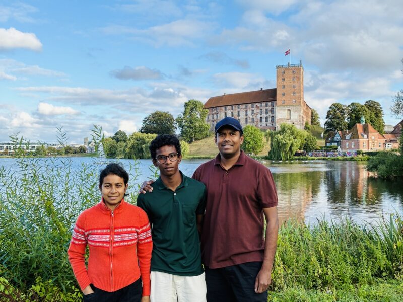 Familie fra Sri Lanka står ved Slotssøen med Koldinghus i baggrunden